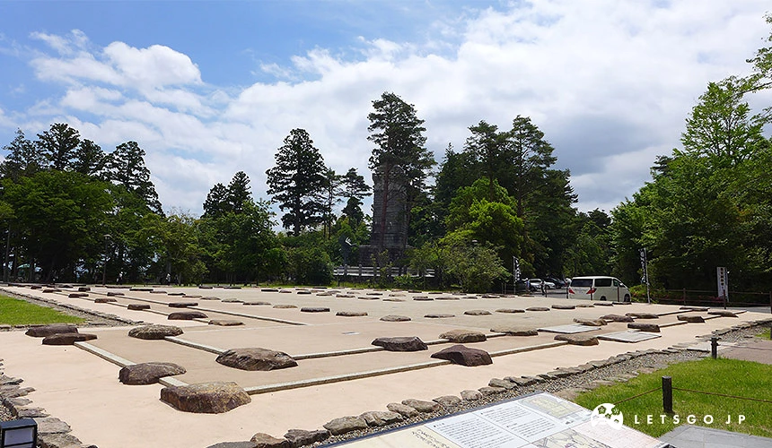 仙台城本丸大廣間建築遺跡,石造基礎排列於草地上,四周圍繞綠樹