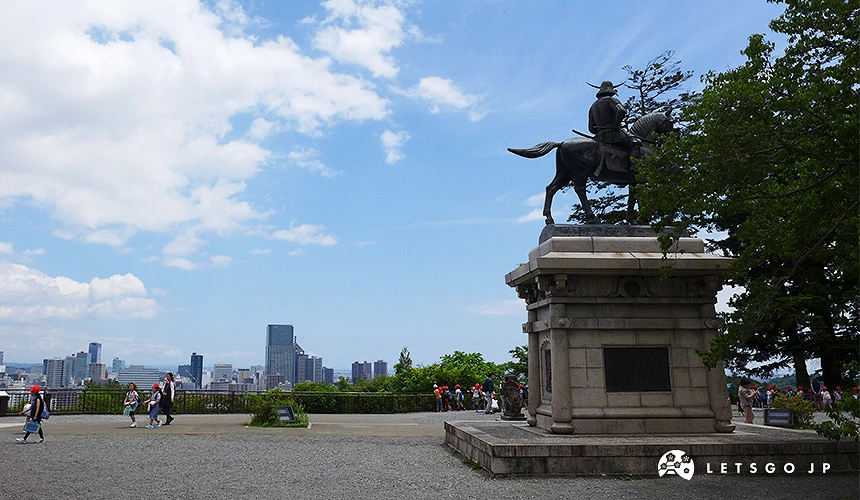 仙台城跡伊達政宗騎馬銅像,背景可見仙台市區與藍天白雲