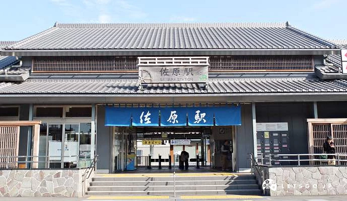 日式瓦屋頂設計的佐原車站站舍外觀,正面掛著藍色布簾寫有站名。