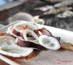 切片的白色花枝呈圓環狀,背景模糊有其他物品