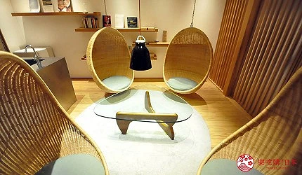 室內空間有兩個蛋形座椅和玻璃桌,牆面裝有木條和書架