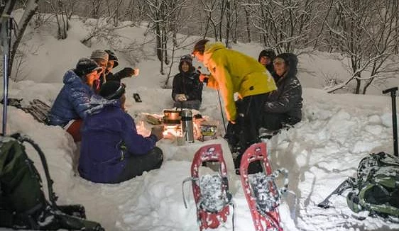 一群人聚集在滑雪場營火的周圍