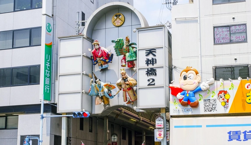 天神橋筋商店街入口標誌與牌樓,展示祭典人物裝飾與街區招牌