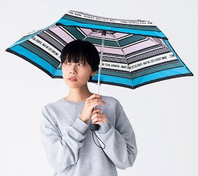 男性撐條紋雨傘向上觀看,展示遮雨範圍