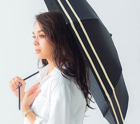 女性撐黑色花紋雨傘側面示範,呈現優雅設計與使用情境