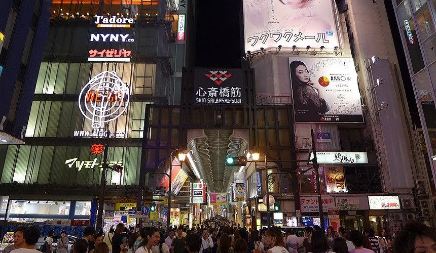 夜晚熱鬧的心齋橋筋商店街入口,人潮擁擠、燈光閃爍,是大阪最具人氣的購物街之一