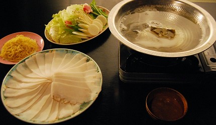火鍋桌面擺放章魚片、蔬菜拼盤與麵條
