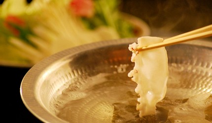 筷子夾起一片章魚片,在火鍋湯中涮煮