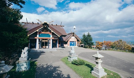 神社建築外觀,前方有石燈籠與寬敞空地