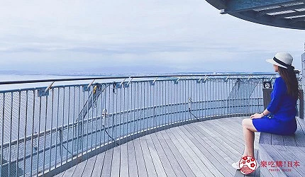 女子坐在展望台欣賞海景