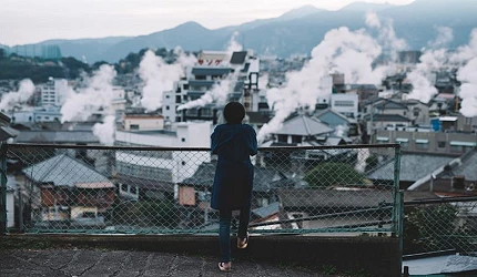 人站在高處看冒煙的鐵輪溫泉