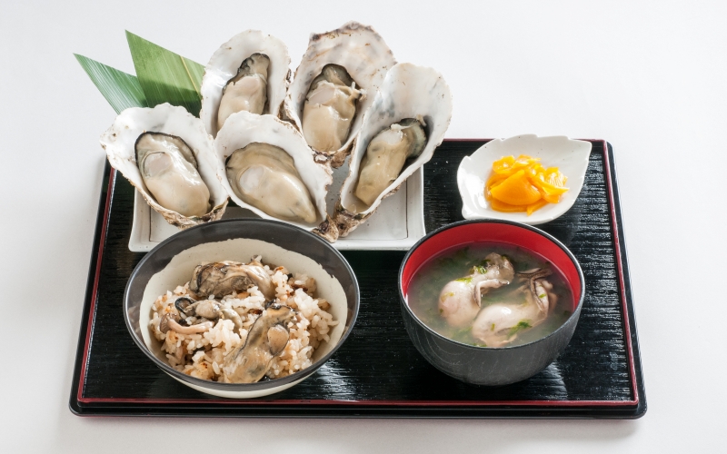 擺在托盤上的牡蠣炊飯、牡蠣湯、生蠔以及漬物