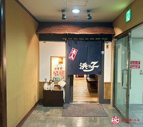室內走廊盡頭的餐廳入口,掛有深藍色布簾,上寫白色日文字