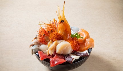海鮮丼盛裝鮭魚、鮪魚、干貝、蝦子、鮭魚卵與其他生魚片