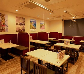 餐廳內部多張淺色桌椅,牆上掛有多幅風景海報
