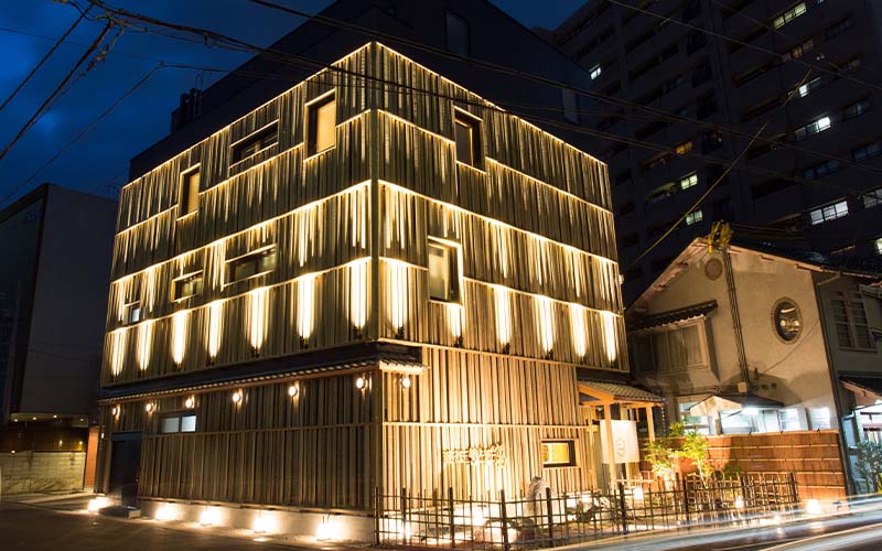 夜間木格柵外牆的多層建築,位於街角並打上燈光