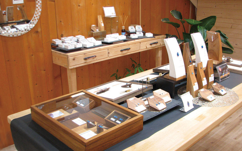 木質風格店內陳列台,玻璃展示盒與白色禮盒整齊排列