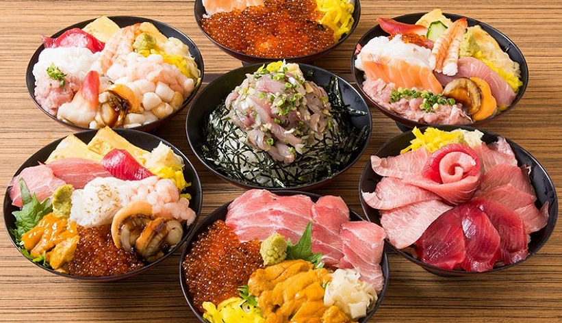 各式海鮮丼排列在桌上,碗中盛有鮪魚、鮭魚卵、海膽等豐富配料。