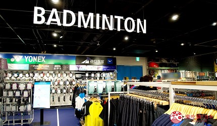 掛著BADMINTON的招牌區域有衣服及球拍
