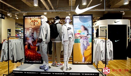 打勾的招牌區域有三個人型展示著休閒服飾，兩旁擺放著服飾商品