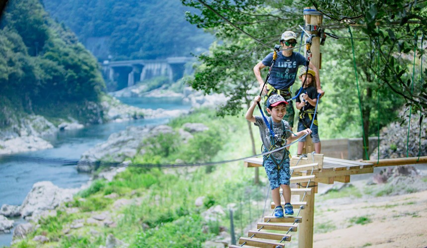 樹林冒險挑戰 Tree Trekking體驗中,小孩站在前面爬著懸空的木梯