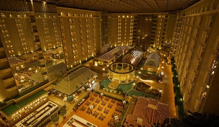 グランドニッコー東京ベイ舞濱飯店內部的挑高大廳中庭，金色燈光營造溫馨氛圍，可見多層樓的開放式設計和現代化裝潢
