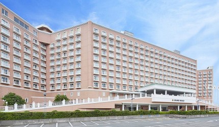 グランドニッコー東京ベイ舞濱飯店的外觀全景，白色現代化建築矗立在東京灣畔，建築設計簡潔大氣，周圍環境開闊