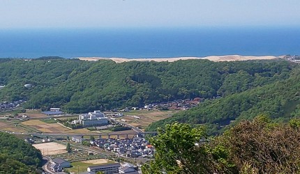 從鳥取城跡高處眺望鳥取市街與日本海,遠方可見鳥取砂丘一帶的海岸線與綠色山丘