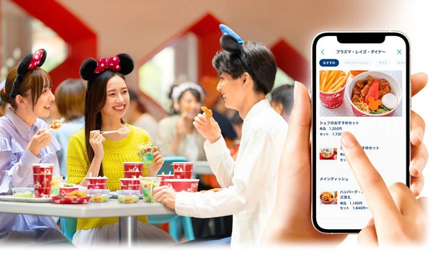 兩個女生一個男生正在迪士尼餐廳享用餐點,右側為點餐app示意圖