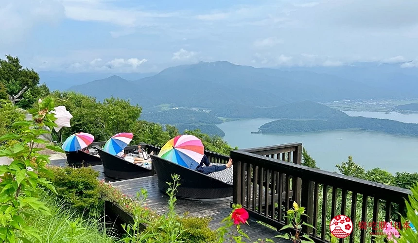 撐著彩虹傘躺在沙發雅座上欣賞美景