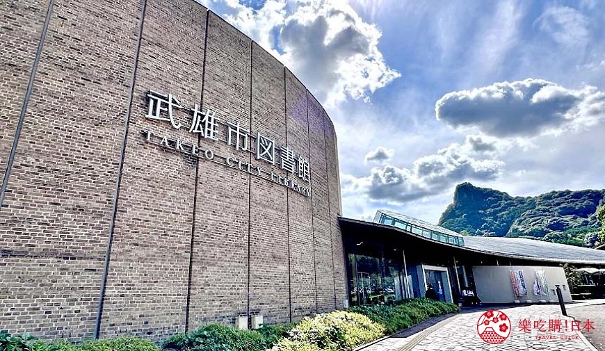 武雄市圖書館弧形磚牆外觀與後方的山丘景色