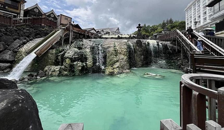 草津溫泉湯畑,溫泉水流經岩石與木製設施的景象