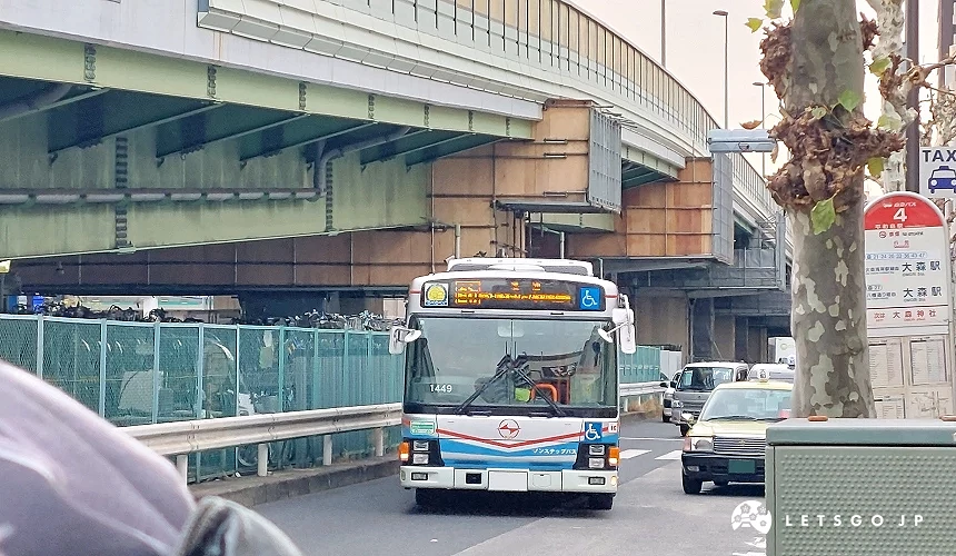 一台巴士在路上行駛,旁邊有幾輛小客