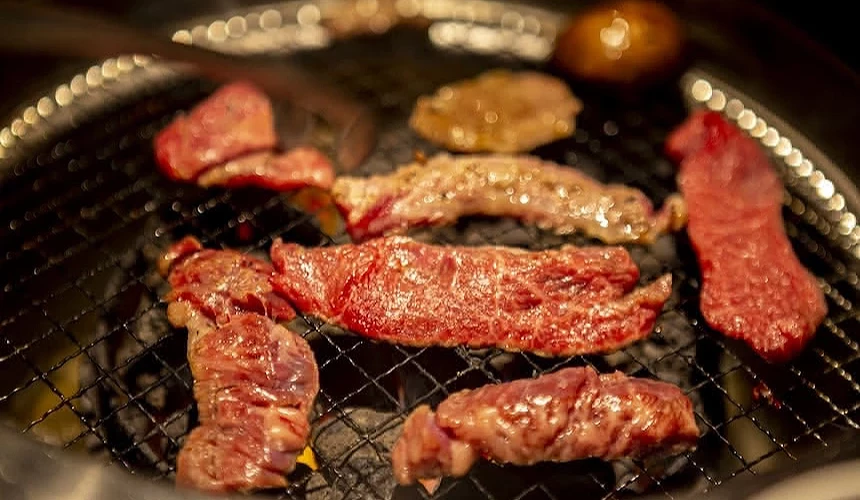烤網上正在滋滋作響、烤至焦糖色的誘人燒肉。