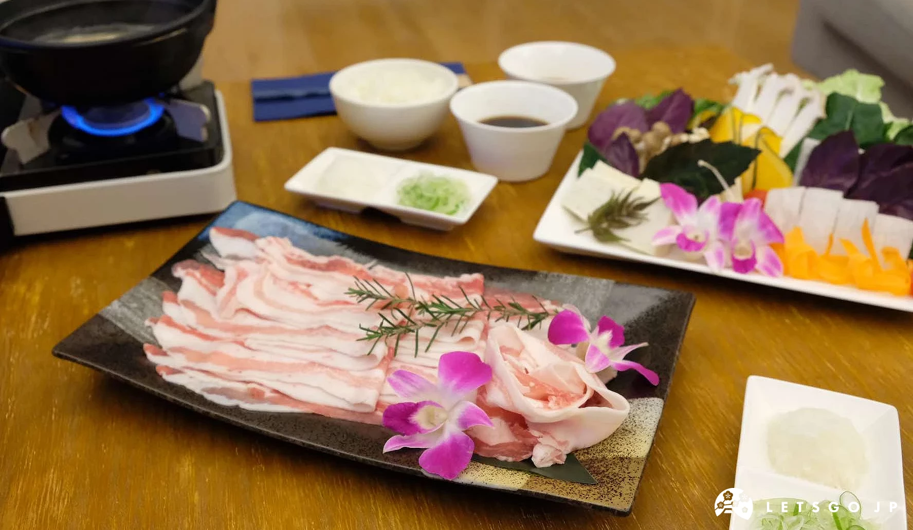 桌上擺放了新鮮肉片與蔬菜的套餐