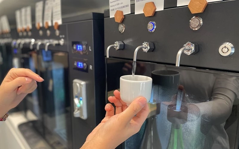 自助清酒機出酒,手持白色酒杯