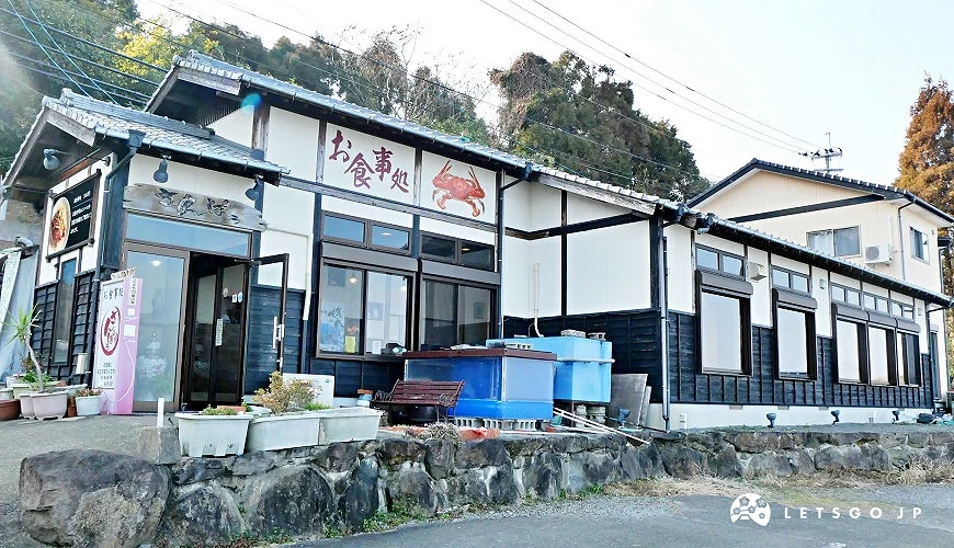 「食事處 三寶」的店門口 白色牆與傳統日式屋瓦,招牌有螃蟹圖示