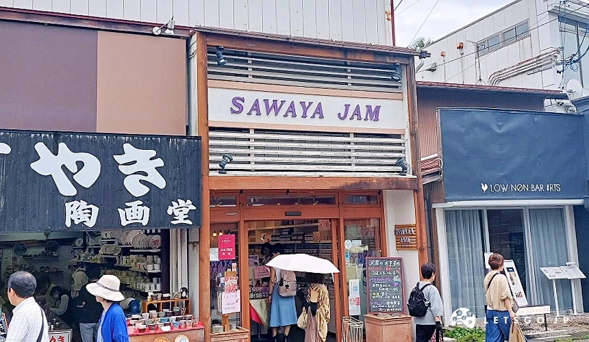 位於舊輕井澤銀座通商店街的澤屋果醬 (SAWAYA JAM) 店面,木質調門面掛著紫色招牌,遊客正進出參購