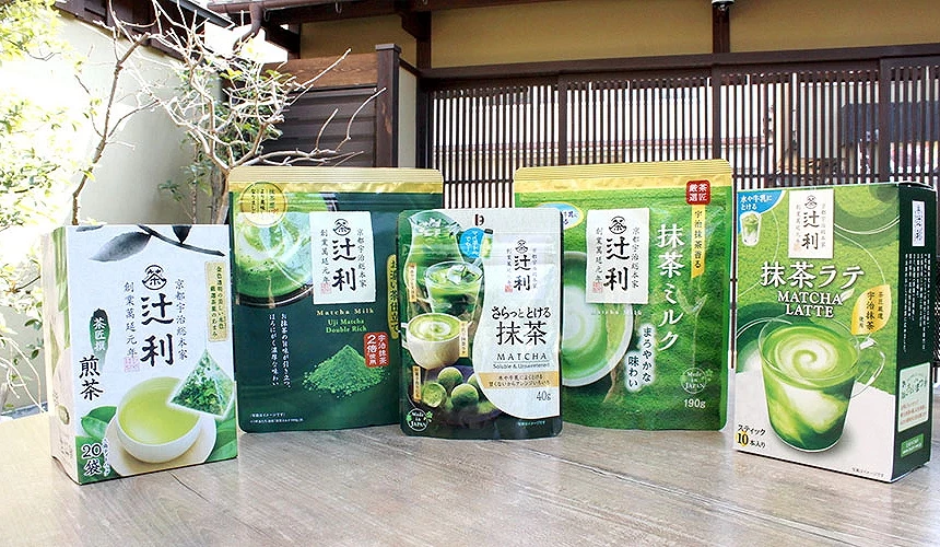 五款辻利抹茶系列商品包裝並排展示,包含煎茶包、抹茶牛奶、高濃度即溶抹茶粉、抹茶ミルク和抹茶拿鐵,背景為日式木格柵