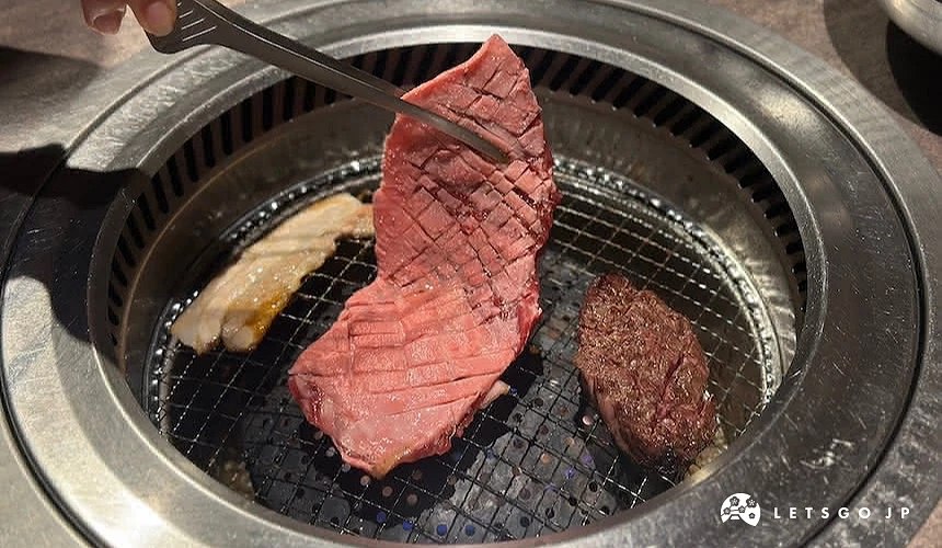 烤網上夾起一大塊牛肉