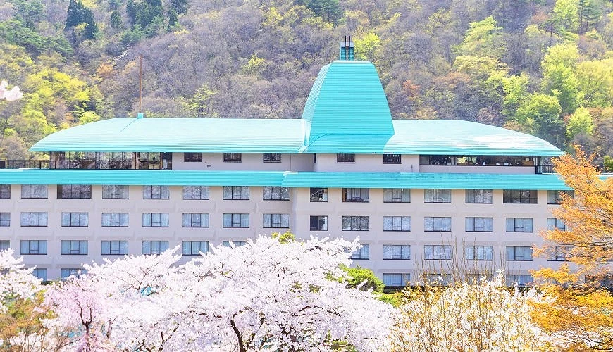 青色屋頂的「花巻飯店」與櫻花前景