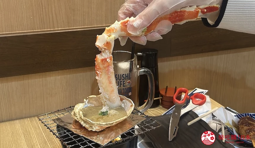 正在將蟹肉沾入蟹膏的手