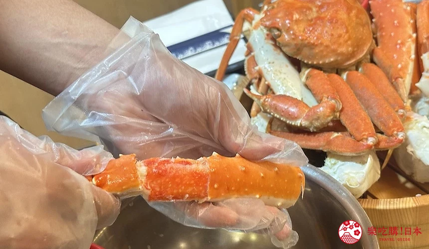 一雙戴著透明手套撥蟹腳殼的手