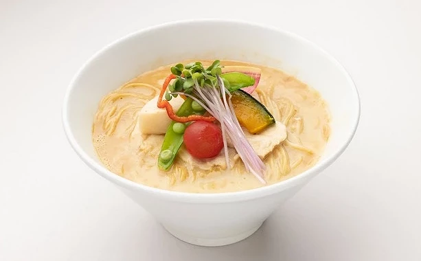 一碗雞白湯拉麵,鋪有南瓜、番茄、豌豆等蔬菜