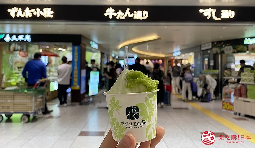 手持毛豆泥聖代,背景為牛舌通及壽司通的入口處