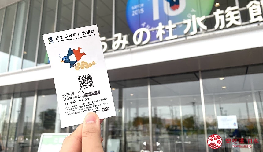 手持水族館門票,背景為水族館入口