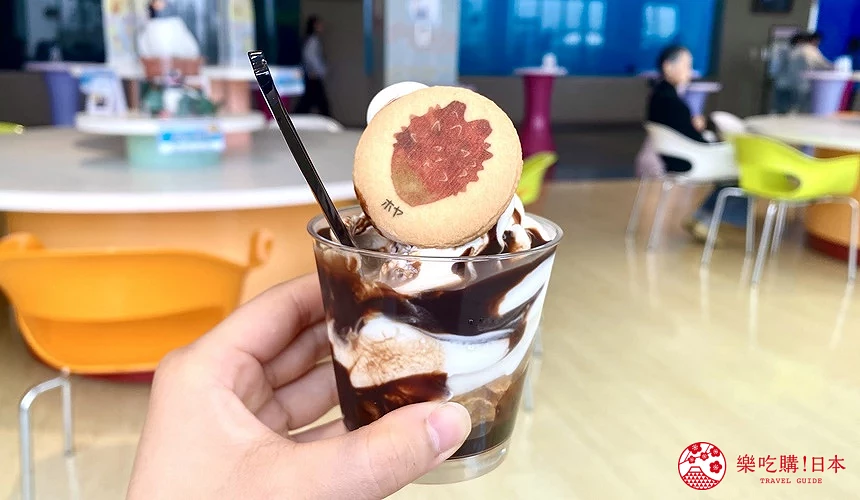 手持巧克力聖代,巧克力聖代上面有海鞘圖案的餅乾