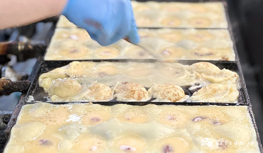 在熱滋滋的鐵盤上製作章魚燒