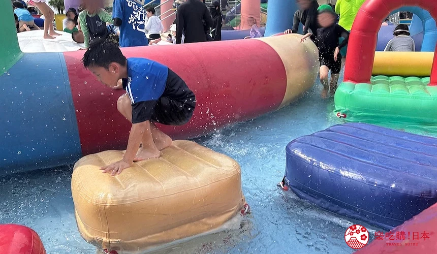 小童站在水池充氣墊上
