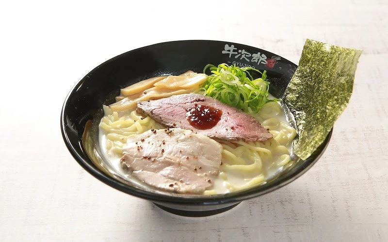 一碗白色湯底，且鋪有兩片叉燒、一片海苔、蔥花和筍乾的拉麵